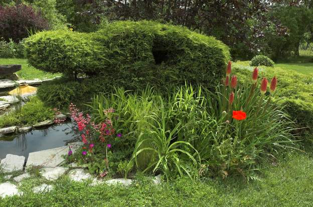 2008 05 Au pied du dragon, un ensemble de fleurs rouges, heuchères, pavot et kniphofia, sur fond de géranium et de poacées.